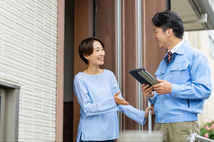 玄関で依頼をする女性と作業員